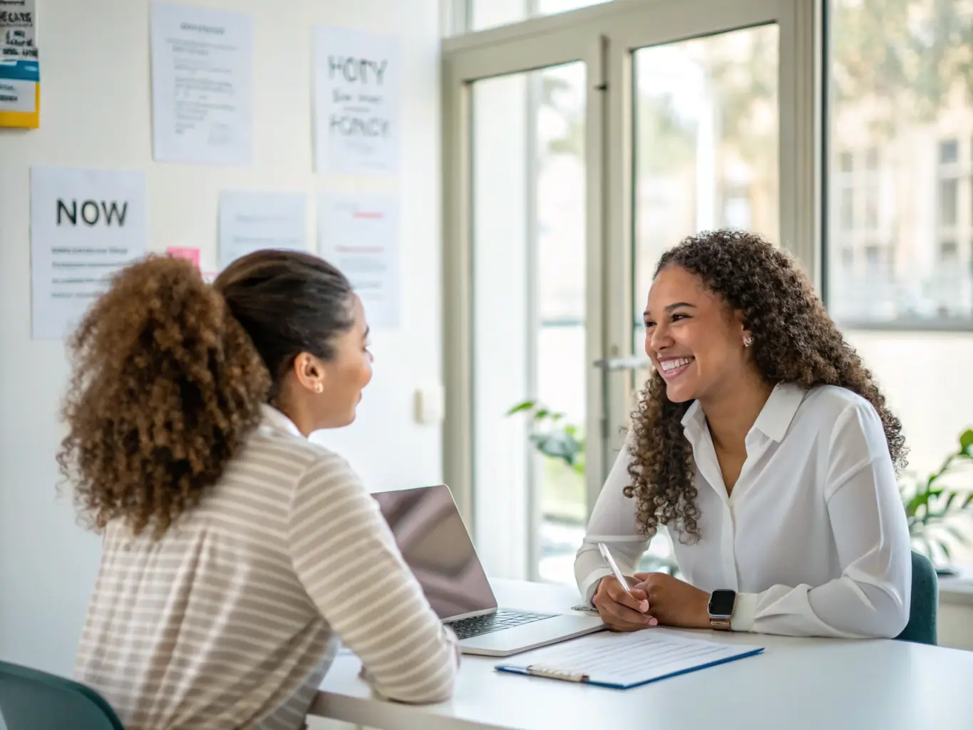 A person participating in a mock interview, receiving constructive feedback from a career consultant in a well-lit office setting. The consultant is providing guidance on improving interview techniques.
